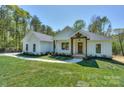 Inviting single-story home featuring a well-maintained lawn and stylish wooden accents on the front porch at 8225 Long Island Rd, Catawba, NC 28609