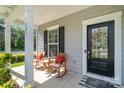 Inviting front porch featuring rocking chairs, stylish door, and elegant wreath decor at 1003 Dorsey Dr, Fort Mill, SC 29715