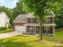 Attractive brick home with a covered front porch, black shutters, and a well-maintained lawn at 1014 Sandbox Cir, Indian Trail, NC 28079