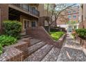 Exterior view of a condo entrance with brick stairs and mature landscaping at 1109 E Morehead St # 22, Charlotte, NC 28204