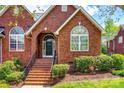 Close-up of brick home's entry featuring a brick staircase leading to the black front door at 1126 Blowing Rock Cv, Fort Mill, SC 29708