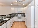 Bright kitchen with white cabinets, stainless appliances, and stylish backsplash at 11705 Silverado Ln, Charlotte, NC 28277