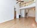 Open-concept living room with fireplace, wood floors, staircase, and entry to a bathroom at 11705 Silverado Ln, Charlotte, NC 28277