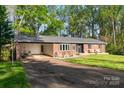Beautiful brick home with an attached carport and a lush green lawn, surrounded by mature trees at 1218 Donna Dr, Shelby, NC 28152