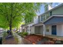 Street view of two-story townhomes with covered front porches and mature trees at 12925 Windy Lea Ln, Huntersville, NC 28078