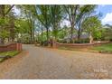 An estate entrance with brick pillars and walls, landscaped with flowers, shrubs and trees at 1441 Carmel Rd, Charlotte, NC 28226