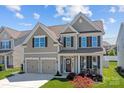 Beautiful two-story home featuring a manicured lawn, two-car garage, and welcoming front porch at 187 Longleaf Dr, Mooresville, NC 28117