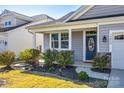 Beautiful home exterior with lush landscaping, a blue front door, and a welcoming porch area, creating curb appeal at 19010 Hawk Haven Ln, Charlotte, NC 28278
