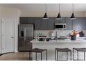 Bright kitchen featuring gray cabinetry, stainless steel appliances, white countertops, and three pendant lights above the island at 2100 Endeavor Run, Charlotte, NC 28269