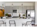 Modern kitchen featuring gray cabinets, stainless steel appliances, a white countertop, and pendant lighting at 2108 Endeavor Run, Charlotte, NC 28269