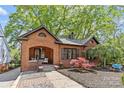 Beautiful brick home features manicured landscaping, black shutters, and inviting front porch at 2125 Kenilworth Ave, Charlotte, NC 28203