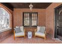 Cozy front porch with brick flooring, comfortable seating, and view of the front yard at 2125 Kenilworth Ave, Charlotte, NC 28203