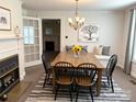 Bright dining area with fireplace, chandelier lighting, and modern decor, perfect for Gathering meals and gatherings at 215 Old Dixie Rd, Lancaster, SC 29720