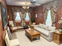 Living room featuring wood paneling, classic furniture, and a decorative ceiling fan for a traditional aesthetic at 215 Old Dixie Rd, Lancaster, SC 29720