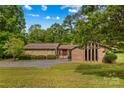 Single-story home featuring stone and brick, mature trees, and a well-maintained lawn at 2281 Old Salisbury Concord Rd, Concord, NC 28025