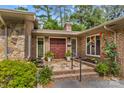 Inviting front entrance features a beautiful brick walkway, lush greenery, and a striking red double door at 2281 Old Salisbury Concord Rd, Concord, NC 28025