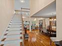 Inviting foyer with hardwood floors, staircase, and an open view to the living and dining areas at 276 Greyfriars Rd, Mooresville, NC 28117