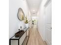 Bright hallway featuring light wood floors, white walls, modern decor, and minimalist design at 327 Lincoln Sw St, Concord, NC 28025