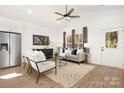 Open-concept living room featuring modern furniture, stainless steel refrigerator and hardwood floors at 327 Lincoln Sw St, Concord, NC 28025