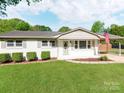 Charming single-story home with American flag, manicured lawn, and inviting front entrance at 4303 Greenhaven Ln, Gastonia, NC 28056