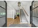 Bright foyer featuring hardwood floors, staircase, modern lighting, and access to living spaces at 438 Wonderwood Dr, Charlotte, NC 28211