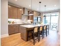 Modern kitchen with stainless steel appliances, island with seating, and access to the outdoor patio at 451 Old Town Village Rd, Waxhaw, NC 28173