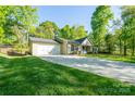 A well-maintained home shows off its long driveway and tidy lawn, complete with a convenient two-car garage at 556 Westwood Dr, Kannapolis, NC 28081