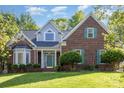 Charming brick home featuring manicured landscaping and a covered porch on a sunny day at 585 Highland Ridge Rd, Mooresville, NC 28115