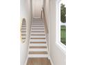A well-lit staircase with white risers, wood treads, and a simple wood handrail at 8048 Cedarsmith Ct, Charlotte, NC 28217