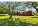 Inviting brick home with a well-maintained lawn and mature trees at 8408 Mcclure Cir, Charlotte, NC 28216