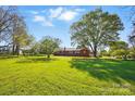 A sprawling lawn with mature trees in front of brick home provides a serene setting at 8408 Mcclure Cir, Charlotte, NC 28216