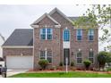 Traditional two-story brick home featuring a well-manicured lawn and attached two-car garage at 8810 Cool Meadow Dr, Huntersville, NC 28078