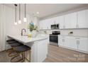 Bright kitchen featuring white cabinetry, stainless steel appliances, and an island with barstool seating at 103 Webb St, Mount Holly, NC 28120