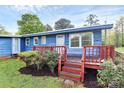 A charming blue home featuring a well-kept lawn, a quaint red porch, and manicured shrubs at 1043 Sid Davis Rd, Chester, SC 29706