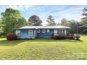 Blue home with a metal roof, a red porch and landscaped yard in a sunny outdoor setting at 1043 Sid Davis Rd, Chester, SC 29706