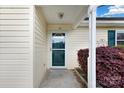 Close up of the front door, showing a storm door and purple bushes at 113 Hidden Creek Dr, Salisbury, NC 28147