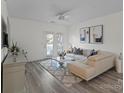 Bright living room featuring wood floors, a comfortable sofa, and a sliding glass door at 11839 Ridgeway Park Dr, Charlotte, NC 28277