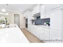 Bright kitchen with white cabinetry, stainless steel appliances, and a stylish tile backsplash at 1303 Links Crossing Dr # 219, Monroe, NC 28112