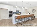 Modern kitchen featuring an expansive island with seating, quartz countertops, and pendant lighting at 1303 Links Crossing Dr # 219, Monroe, NC 28112