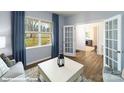 Cozy living room with natural light, neutral tones, and French doors leading to another room at 134 Falling Up Ln, Salisbury, NC 28147