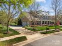 Gorgeous home boasting a manicured lawn, brick facade, covered porch, attached garage, and long driveway at 135 Northbridge Dr, Mooresville, NC 28115