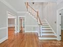Spacious foyer with hardwood floors, staircase, and crown molding at 1413 Willow Oaks Trl, Weddington, NC 28104