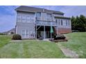 Backyard features a well-maintained lawn, covered deck, patio area with seating, and lush greenery at 143 S Gibbs Rd, Mooresville, NC 28117