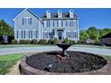 Elegant two-story home with manicured landscaping, circular driveway, and decorative fountain at 143 S Gibbs Rd, Mooresville, NC 28117