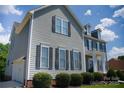 This attractive two-story home boasts gray siding, black shutters, a two car garage, and well maintained landscaping at 143 S Gibbs Rd, Mooresville, NC 28117