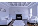 Elegant living room showcasing a coffered ceiling, fireplace, and stylish white furnishings at 143 S Gibbs Rd, Mooresville, NC 28117