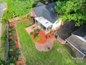 Aerial view of backyard with lush greenery, mulched garden beds, and a sunroom at 1473 12Th Street Nw Dr, Hickory, NC 28601