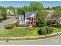 Charming two-story home with a well-manicured lawn and blooming flowers, showcasing curb appeal in a residential neighborhood at 16718 Hampton Crossing Dr, Huntersville, NC 28078