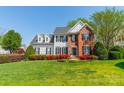 Beautiful two-story home with a well-maintained lawn, featuring a mix of siding and brick with black shutters at 16718 Hampton Crossing Dr, Huntersville, NC 28078