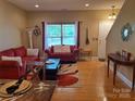 Inviting living room featuring hardwood floors, a bright window, and comfortable seating at 2206 Golden Larch Ln, Waxhaw, NC 28173